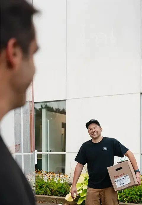 Un technicien souriant de Portes Bourassa Laliberté tenant une boîte.
