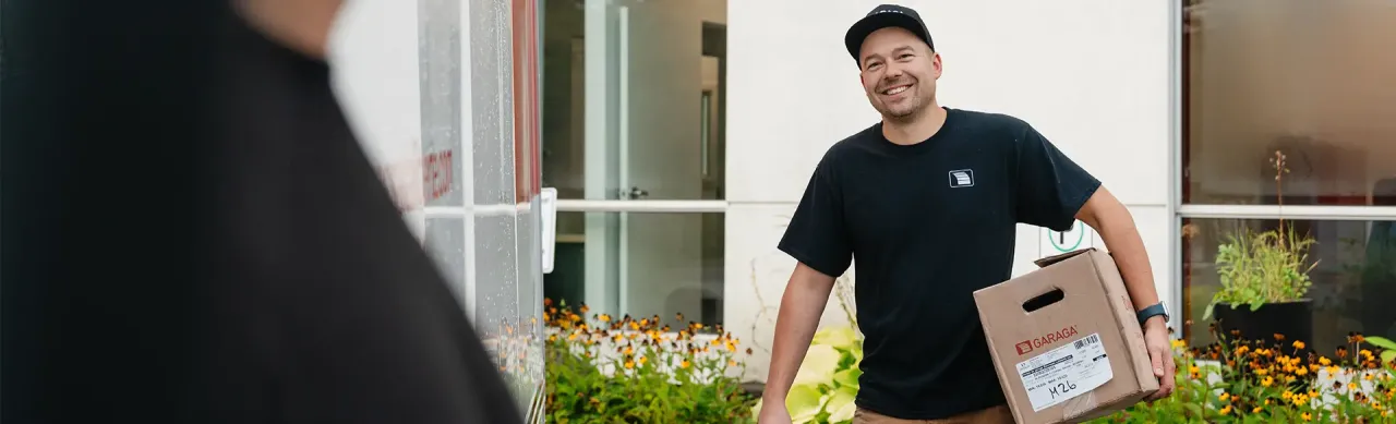 Un technicien souriant de Portes Bourassa Laliberté tenant une boîte.