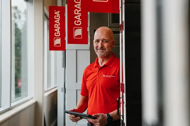 Smiling technician with garage doors