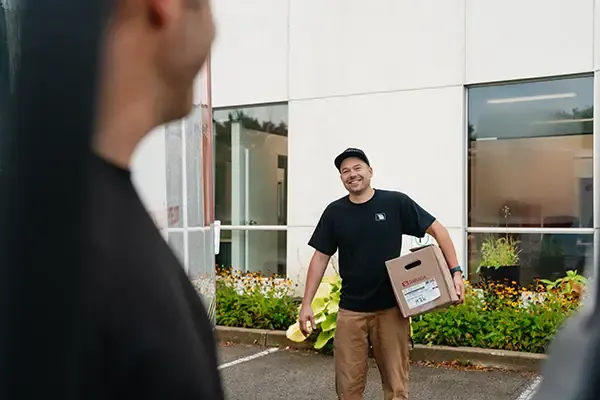 Smilling installer with a box under his arm