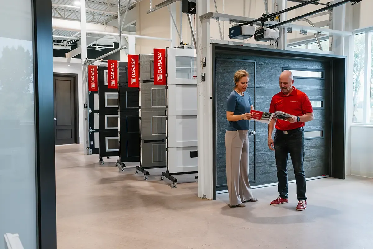Cliente et conseiller dans la salle de montre de porte de garage