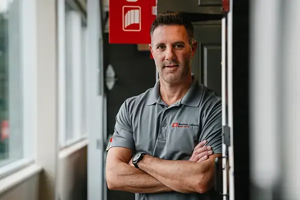 Conseiller souriant appuyé sur des portes de garage